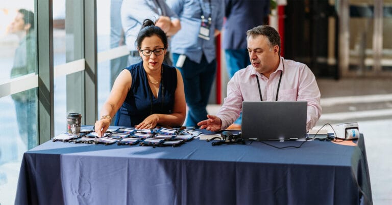 Conference check in desk with staff preparing delegate badges